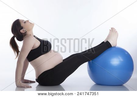 Pregnant Woman Is Doing Exercises With Gymnastic Ball On White Background