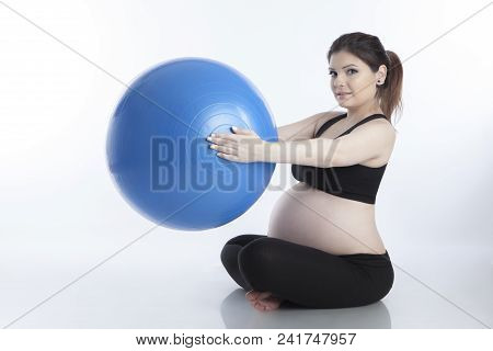 Pregnant Woman Is Doing Exercises With Gymnastic Ball On White Background