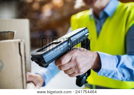 Unrecognizable Warehouse Woman Worker Or Supervisor Using A Mobile Handheld Pc With Barcode Scanner.