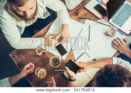 Young Cheerful People Smile And Gesture While Relaxing In Pub. Team Job. Photo Young And Mature Busi
