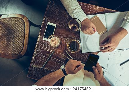 The Hands Of Young People Working And Relaxing In Pub. Team Job. Photo Businessmans Working With New