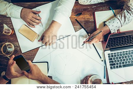 The Hands Of Young People Working And Relaxing In Pub. Team Job. Photo Businessmans Working With New