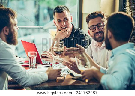 Young Cheerful People Smile And Gesture While Relaxing In Pub. Team Job. Photo Young And Mature Busi