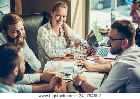 Young Cheerful People Smile And Gesture While Relaxing In Pub. Team Job. Photo Young And Mature Busi