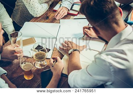 Young Cheerful People Smile And Gesture While Relaxing In Pub. Team Job. Photo Young And Mature Busi