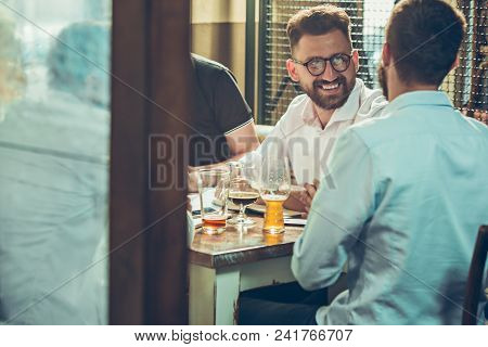 Young Cheerful People Smile And Gesture While Relaxing In Pub. Team Job. Photo Young And Mature Busi