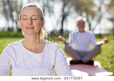 Absolute Calmness. Pleasant Aged Woman Closing Her Eyes While Feeling Absolutely Calm