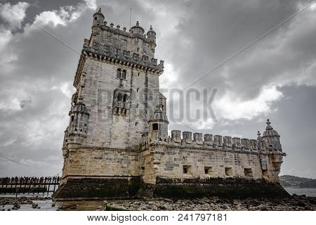 Bottom View Of Lisbon Torre De Belem Against Cloudy Sky And Low Tide