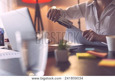 Detail Of Businesswoman Holding A Stapler And Joining Pages Of A Contract With It. Focus On The Stap