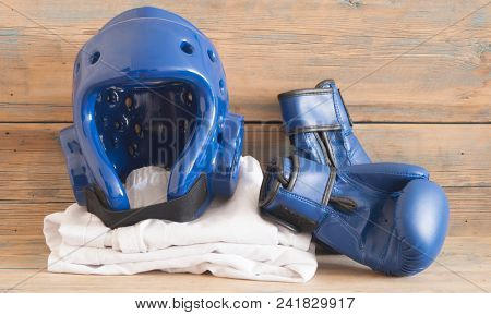 set Taekwondo equipment on a wooden background stock photos. Sports, martial arts. Protective equipment for fight in full contact