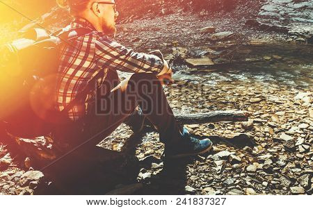 Hiking Travel Camp Scout Concept. Handsome Traveler Man With Backpack Siting On The Stomes And Enjoy