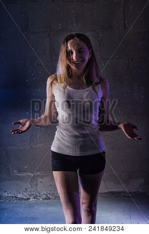 Portrain Of The Girl In The White Shirt With Water Drop In A Dark Room Illuminated By Light During A