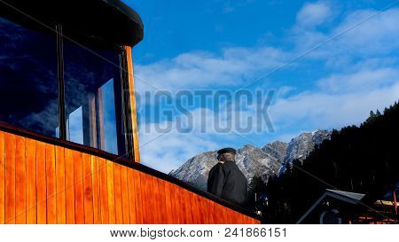 The Captain Of The Steam Ship Tss Earnslaw Stands On The Upper Deck Looking Out To The Mountains In 