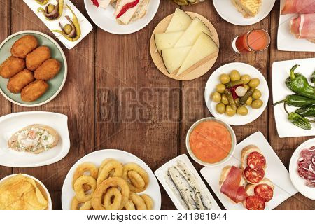 Food Of Spain. An Overhead Photo Of Many Different Spanish Tapas, Shot From Above On A Dark Rustic T