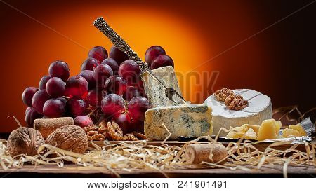 Different Types Of Cheese, Vintage Knife And Fork For Cheese And Grapes. Dark Background. Place For 