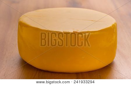 Round Head Of Delicious Cheese On Wooden Board Of Acacia, Close Up.