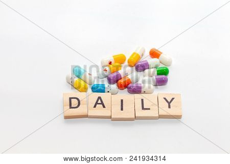 Word Daily With Colorful Pill On White Background