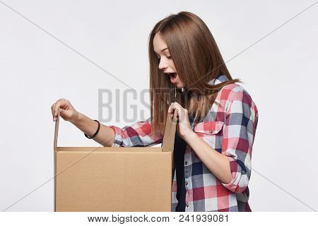 Side View A Happy Surprised Girl Opening A Box Looking Into It