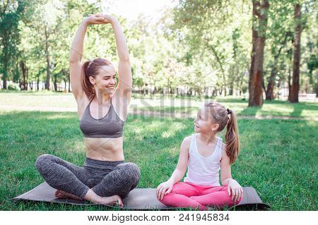 Nice Picture Of Mother And Daughter Sitting On One Carimate. They Are Sitting In Lotus Position. Wom