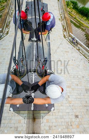 Industrial Climbers Are Applying Silicone On Joints Between Windows