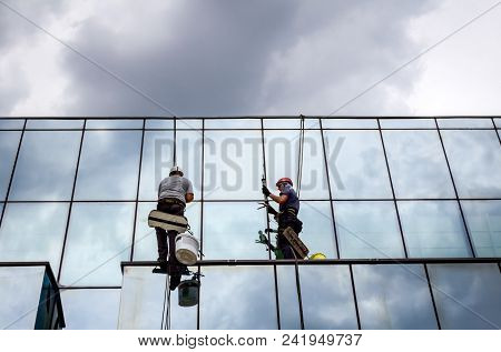 Industrial Climbers Are Applying Silicone On Joints Between Windows