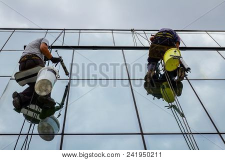 Industrial Climbers Are Applying Silicone On Joints Between Windows