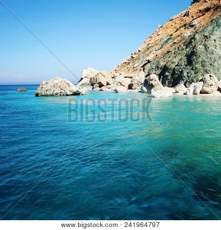 Rocky Shore. Southern Coast Of Turkey. Calm Blue Sea And Clear Sky. Small Beach On The Island Near A