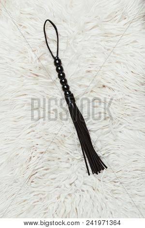 Black Leather Flogging Whip On White Carpet