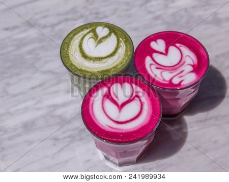 Three Colorful Beetroot, Matcha Lattes Are On The Marble Table With Art Floor On The Background, Tre