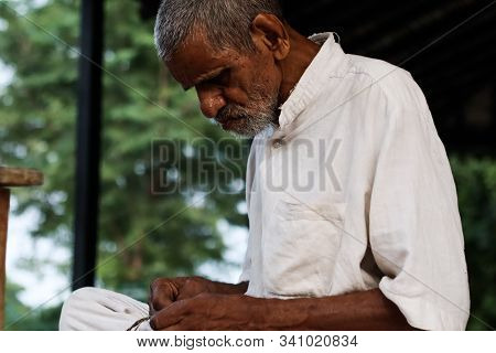 November 30, Maharashtra India, - An Elderly Man In White Dress Sweing Cloth At Gandhi Ashram At Sev
