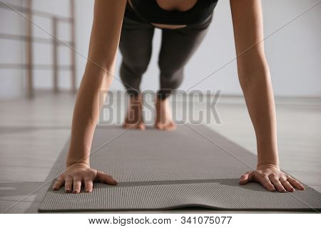 Young Woman Practicing Plank Asana In Yoga Studio, Closeup. Phalankasana Pose