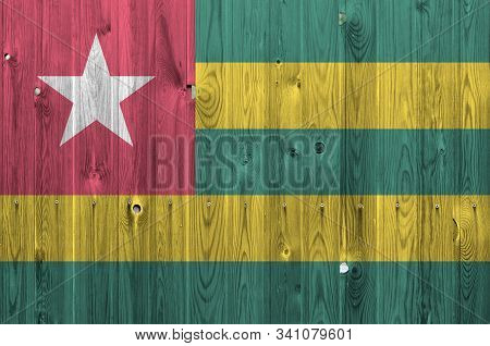 Togo Flag Depicted In Bright Paint Colors On Old Wooden Wall. Textured Banner On Rough Background