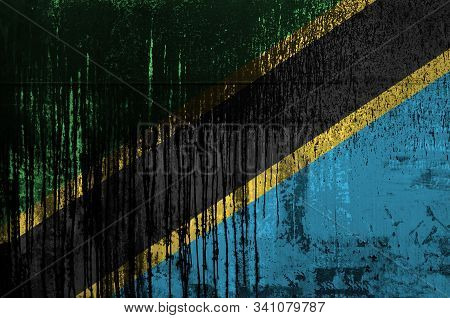 Tanzania Flag Depicted In Paint Colors On Old And Dirty Oil Barrel Wall Closeup. Textured Banner On 