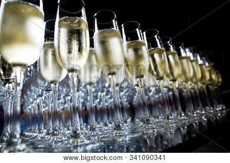 Many Champagne Glasses Stand On A Glass Table