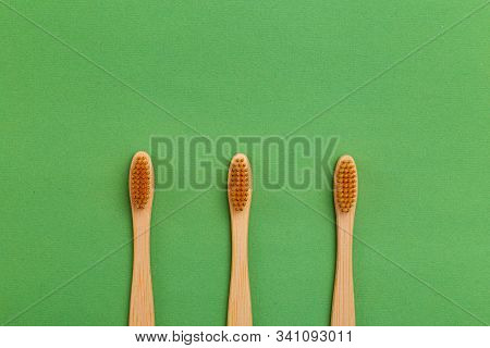 Wooden Toothbrush On Gren Background. Reusable. Minimalist Concept