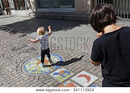 Jonkoping, Sweden - July 5, 2019: Little Brother And Big Brother Doing Hopscotch In The City