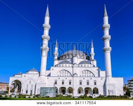 The delightful white Melike Hatun Mosque in Ankara (Turkey). Beautiful muslim temple with four minarets on a background of green lawn on a sunny day
