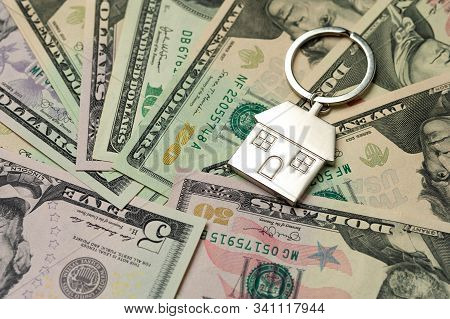 Close-up Keychain In The House Shape And Lies On Paper Dollar Bills. Mortgage Concept Repair Styles 