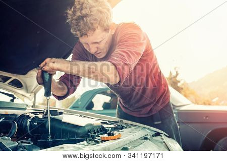 The Concept Of Disability Of People And Their Adaptation To Life. A Blond Disabled Man Repairs A Car