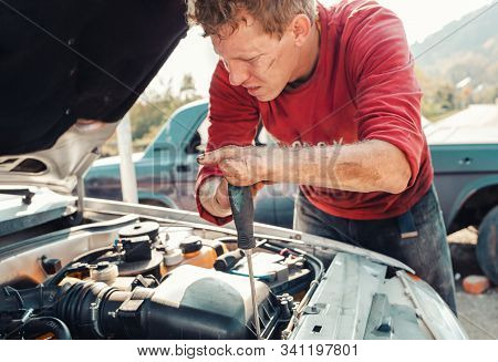 The Concept Of Disability Of People And Their Adaptation To Life. A Blond Disabled Man Repairs A Car