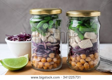 Glass Jars With Healthy Meal On Wooden Table