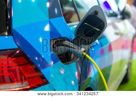 Charging An Electric Or Hybrid Phev Car With The Power Cable Supply Plugged In. Electric Car Chargin