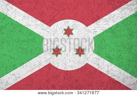Burundi Flag Depicted In Bright Paint Colors On Old Relief Plastering Wall. Textured Banner On Rough