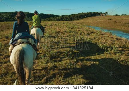Cambara Do Sul, Brazil - July 18, 2019. Girl And Man Riding Horse In A Landscape Of Rural Lowlands C