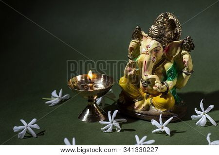Hindu God Ganesha. Ganesha Idol. A Colorful Statue Of Ganesha Idol On Dark Background. Space For Tex