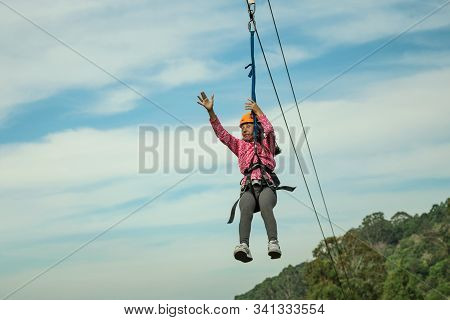 Canela, Brazil - July 21, 2019. Little Girl Descending By Cables In A Sport Called Zip-line Over Gre