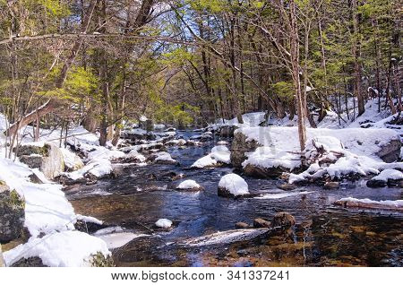 A Small Stream Flowing Down Through Enders State Forest In Granby Connecticut On A Sunny Winter Day.