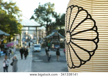 A Lantern In Front Of A Defocussed Background Of Shrine Goers In Japan
