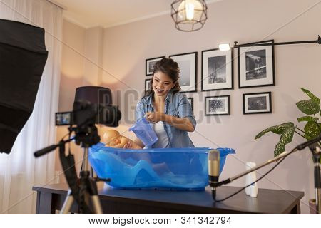 Female Vloger Recording Video About Newborn Baby Bathing As Part Of Online Prenatal Classes; Female 