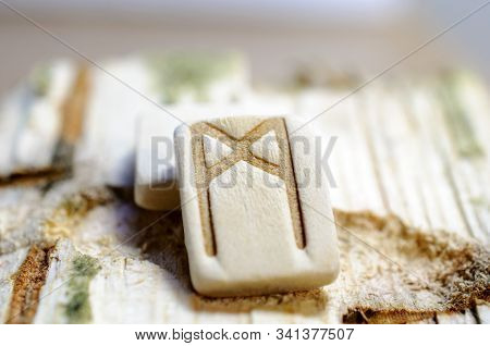 Wooden Rune Mannaz Close Up On A Wooden Background. Soft Focus